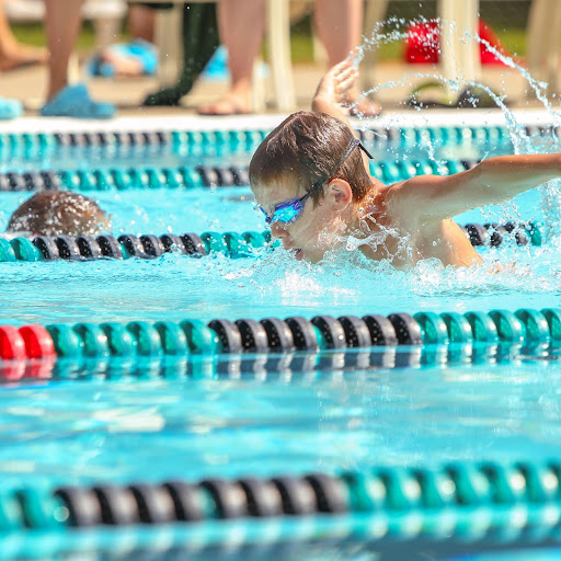 two boys racing each other in different swimming lanes