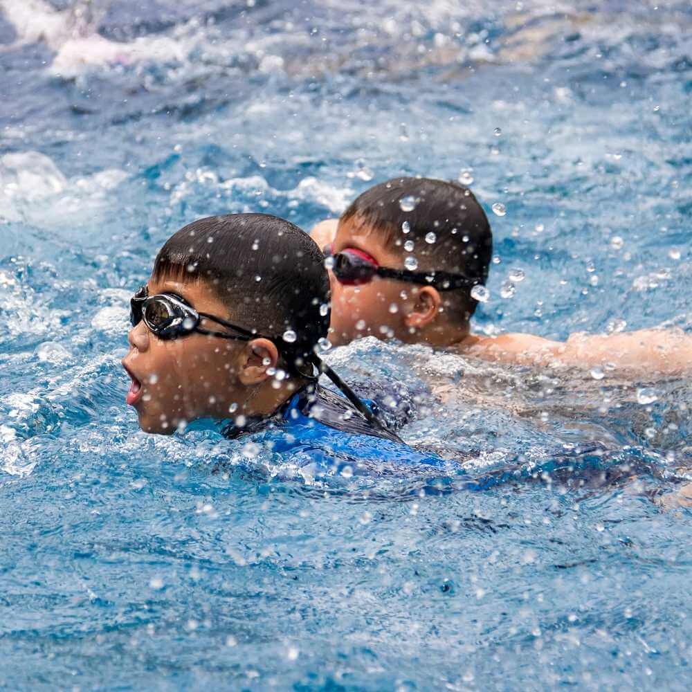 two boys racing in a pool